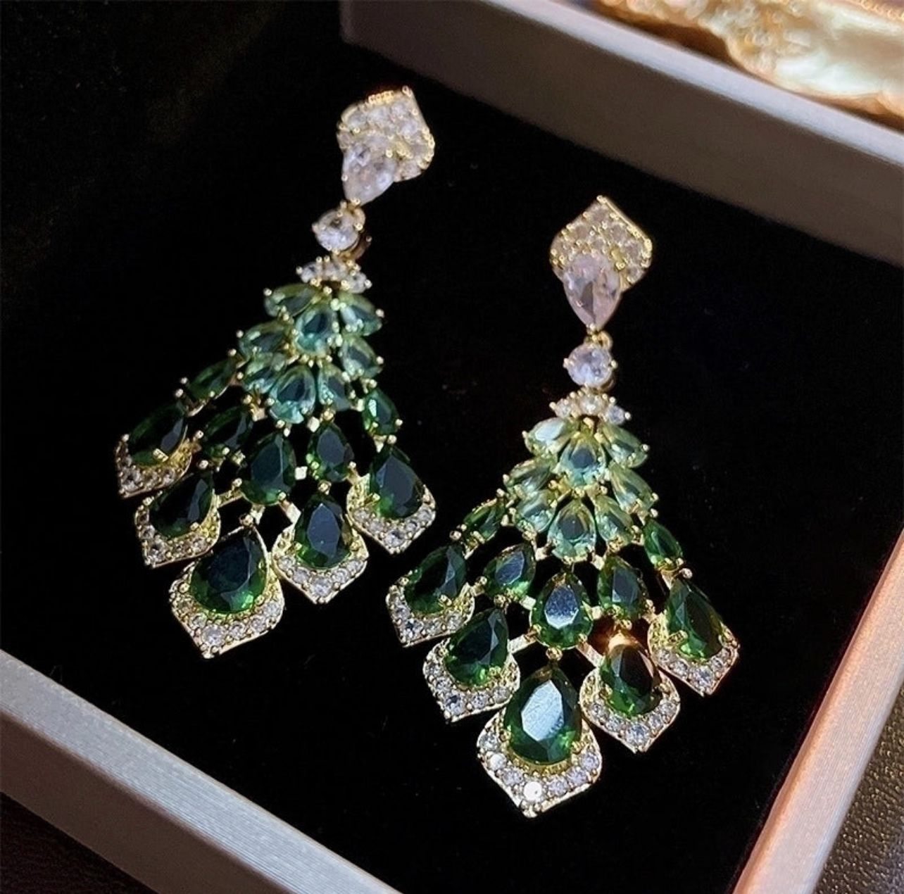 Make a bold statement with these emerald green chandelier earrings. Featuring sparkling crystal drops in a gold-tone setting, perfect for weddings, parties, or elegant evenings.